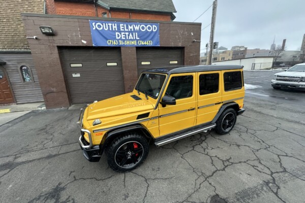 yellow 2016 Mercedes-Benz AMG G63, parked outside a building with a sign that reads "SOUTH ELHWOOD DETAIL"