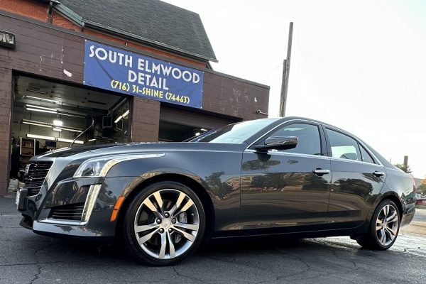 car is parked outside a building with a sign that reads "SOUTH ELMWOOD DETAIL."
